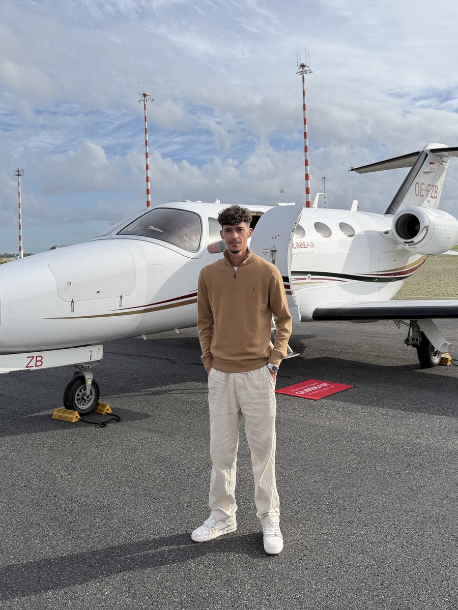 Rodrigo em frente a um jato numa pista